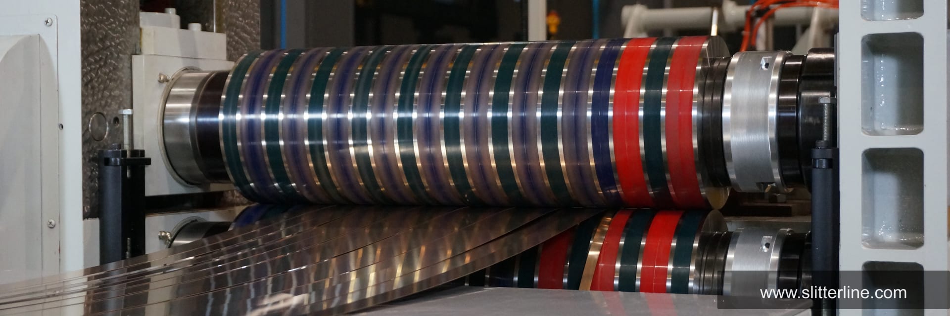 Industrial slitting machine with precision slitter knives in operation